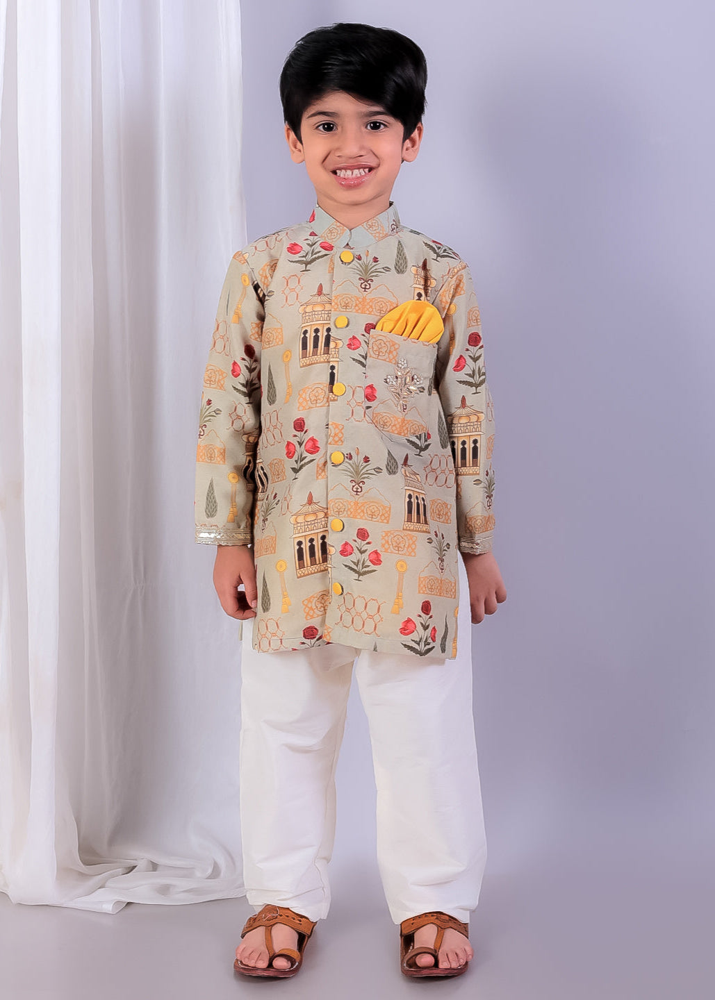 Child wearing a traditional outfit with a patterned jacket and white pants