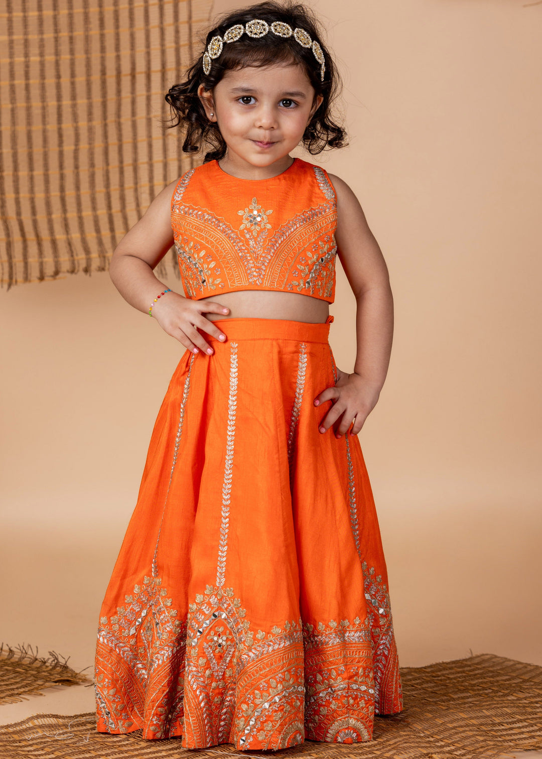 Young girl in an orange traditional outfit with intricate designs
